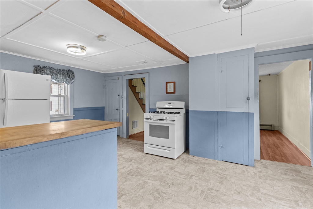79 Beacon Street Lawrence, MA 01843 - Photo 6 of 29 a view of a kitchen with a stove cabinets and a hallway