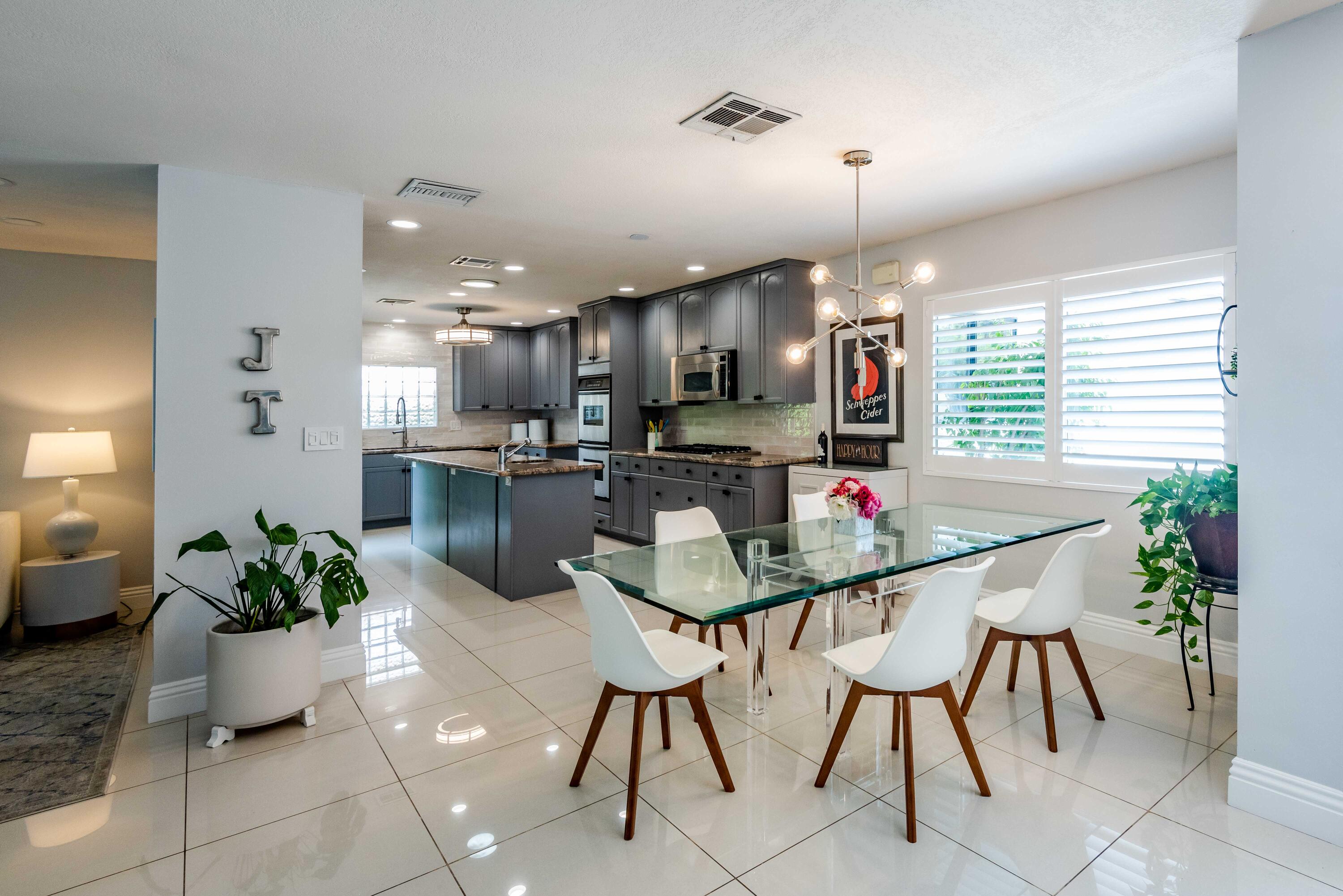 263 East Morongo Road Palm Springs, CA 92264 - Photo 7 of 29 a kitchen with stainless steel appliances kitchen island granite countertop a dining table chairs and white cabinets