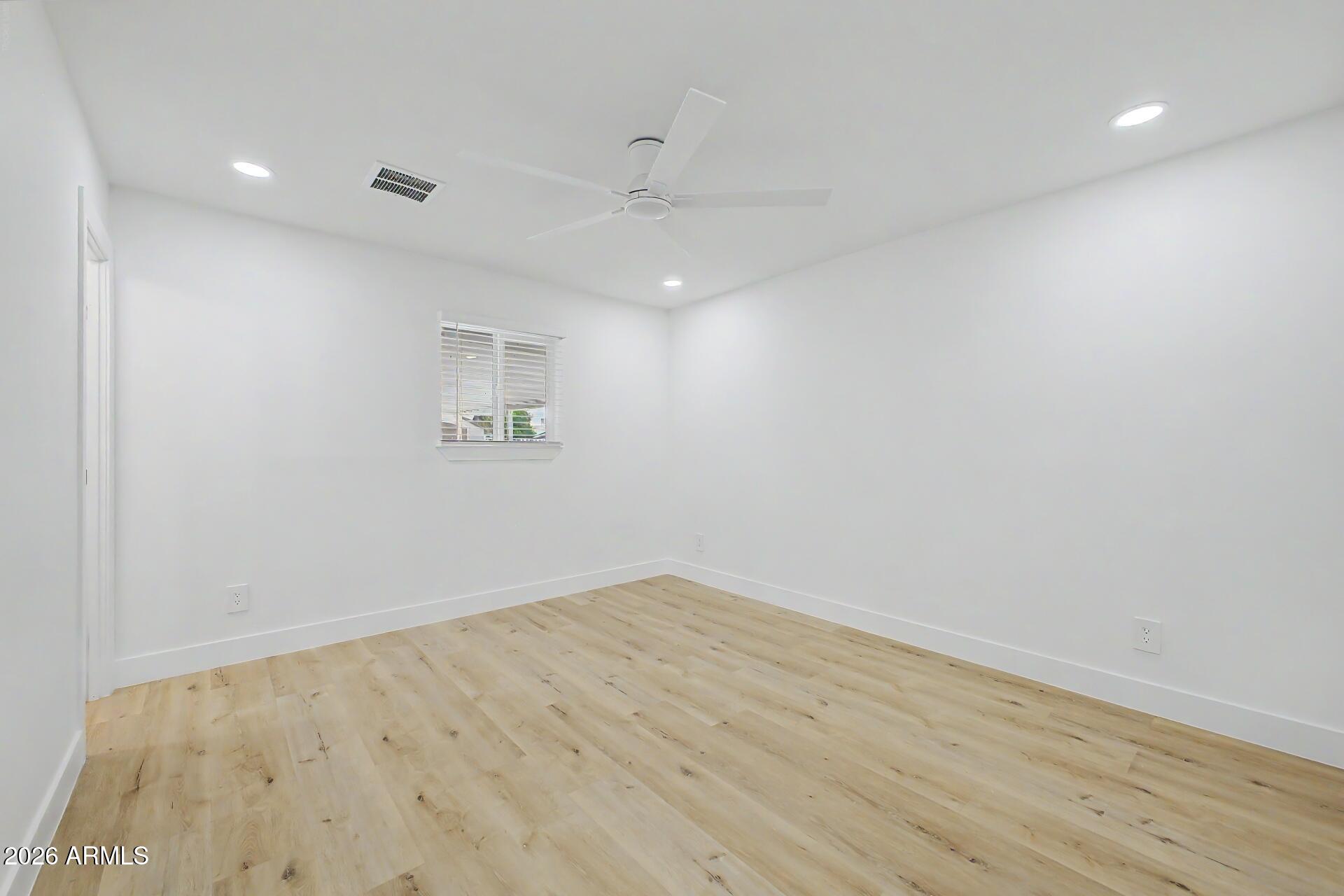 5232 West Hearn Road Glendale, AZ 85306 - Photo 11 of 32 an empty room with wooden floor and windows