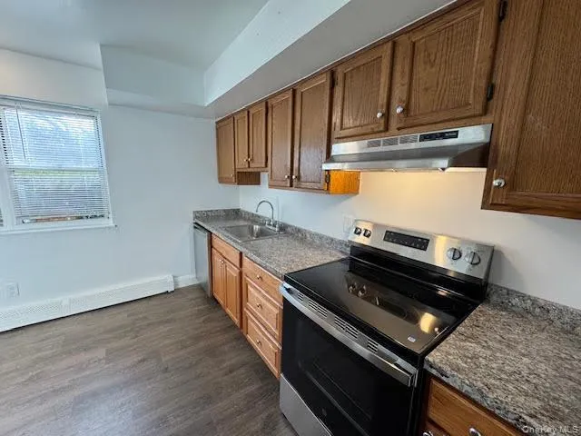 a kitchen with wooden cabinets and a stove top oven