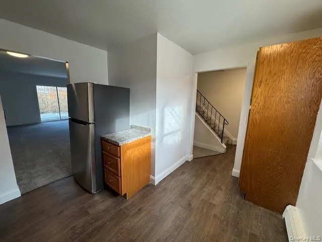 a view of a kitchen with wooden floor and electronic appliances
