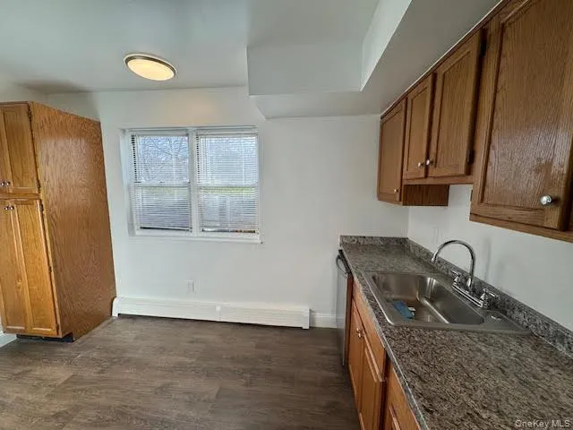 a kitchen with granite countertop a sink a stove and a refrigerator