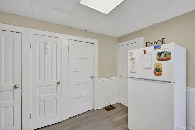 a spacious bedroom with a bed a chandelier and mirror