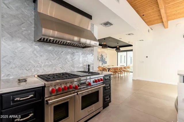 a kitchen with stainless steel appliances granite countertop a stove a sink and a dining table