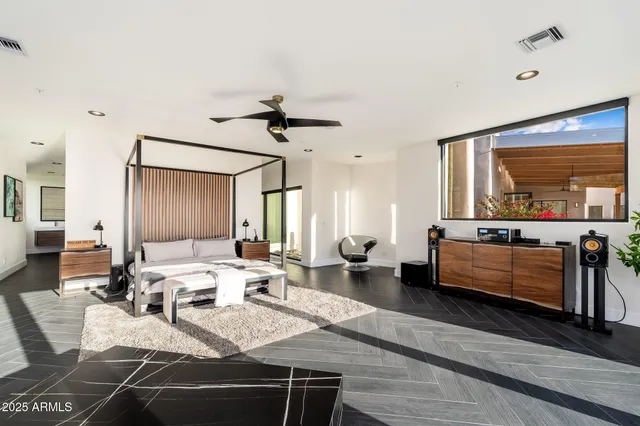 a bedroom with a bed a chair and a chandelier