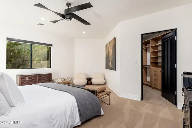 a kitchen with stainless steel appliances a sink a stove a refrigerator cabinets and a window