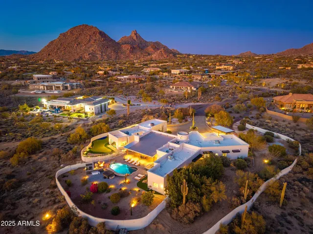 a view of a white house with a yard and potted plants