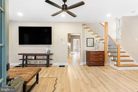 a living room with furniture a wooden floor and a flat screen tv