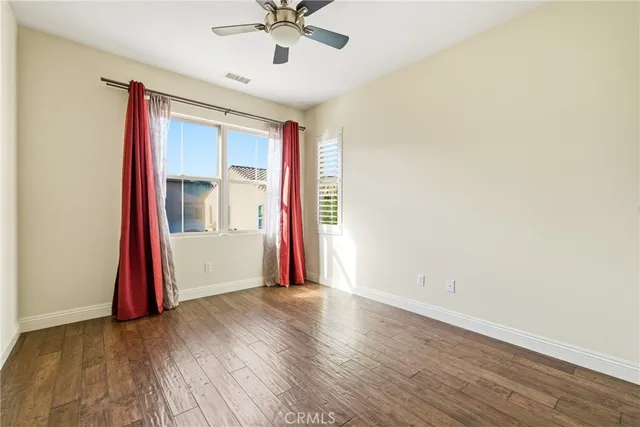 a view of a livingroom with wooden floor and a ceiling fan