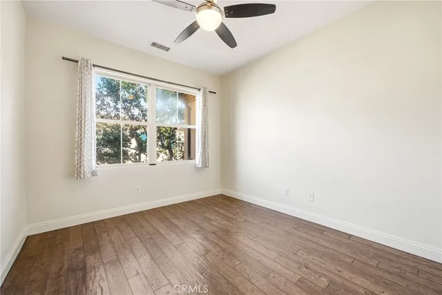 an empty room with a window and wooden floor