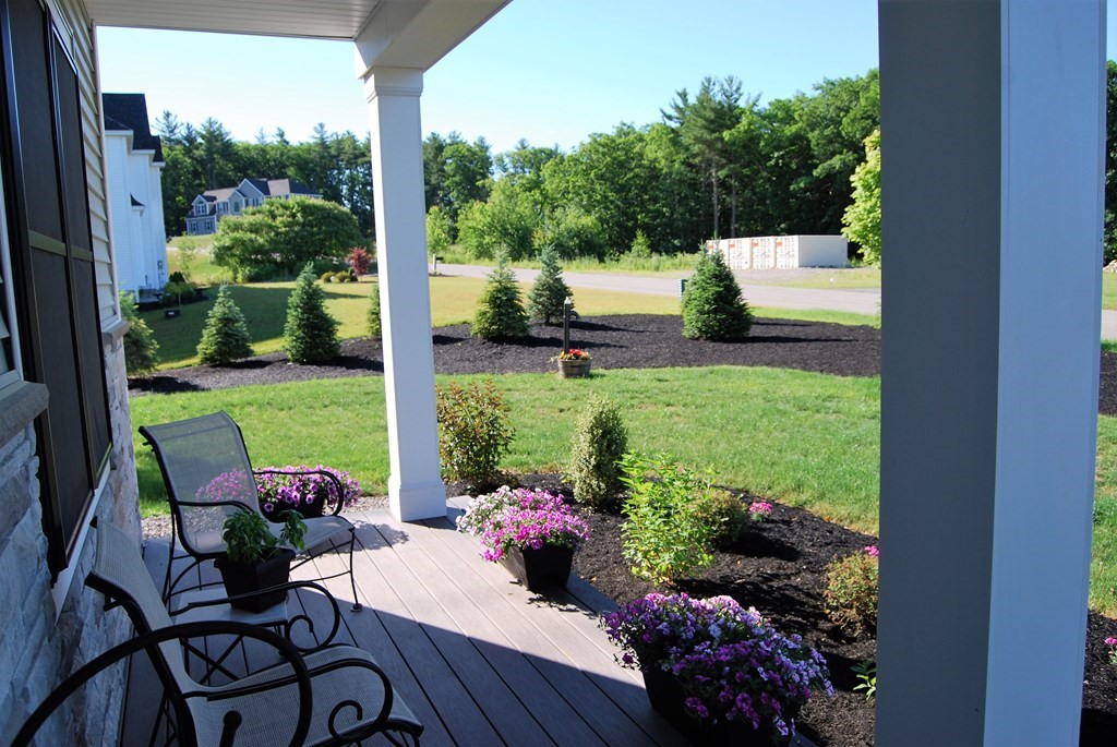 70 Ryan Farm Road, Unit 13 Windham, NH 03087 - Photo 3 of 13 a view of a chairs and table in patio with a yard