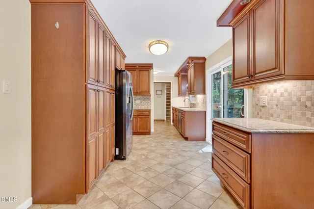 a kitchen with stainless steel appliances granite countertop a refrigerator and a stove top oven