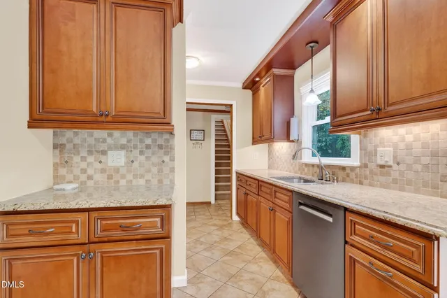 a kitchen with stainless steel appliances granite countertop wooden cabinets a sink and dishwasher