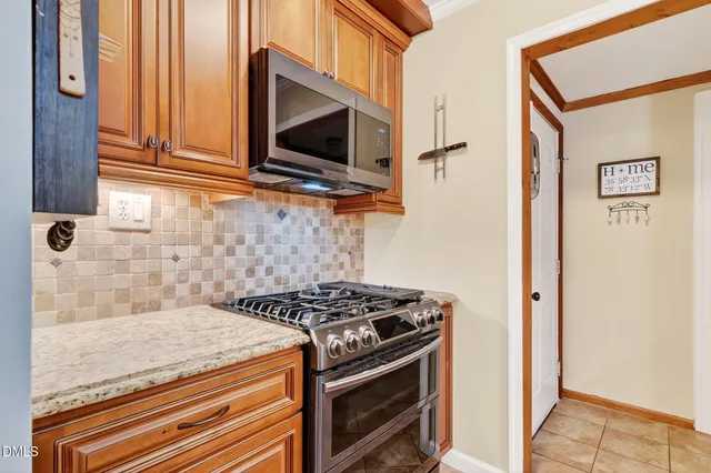 a kitchen with stainless steel appliances granite countertop a stove and a microwave