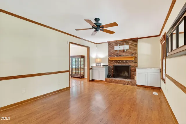a view of an empty room with a fireplace and a window