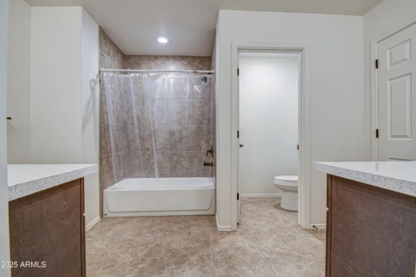 a bathroom with a tub a toilet and a shower