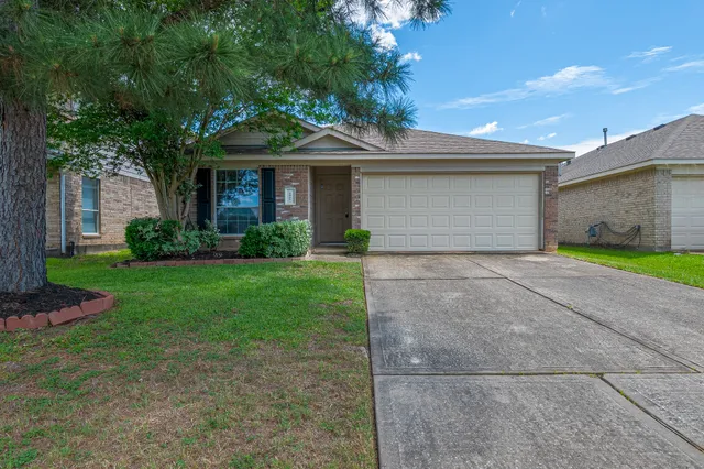 a front view of a house with a garden and yard