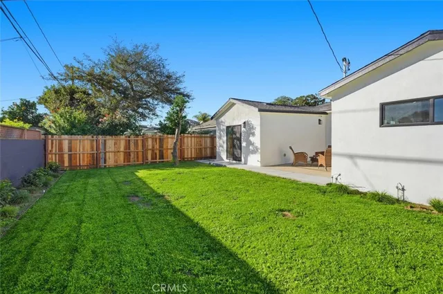 a view of a backyard with plants and large trees