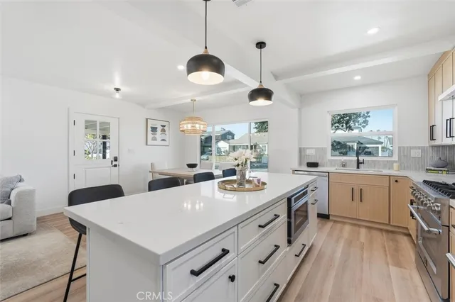a kitchen with a stove a sink a dining table and chairs
