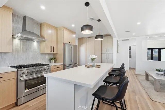 a kitchen with a stove a chandelier and wooden floor