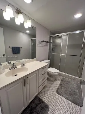 a bathroom with a sink a toilet a mirror and shower