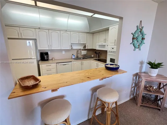 a kitchen with a table chairs refrigerator and microwave