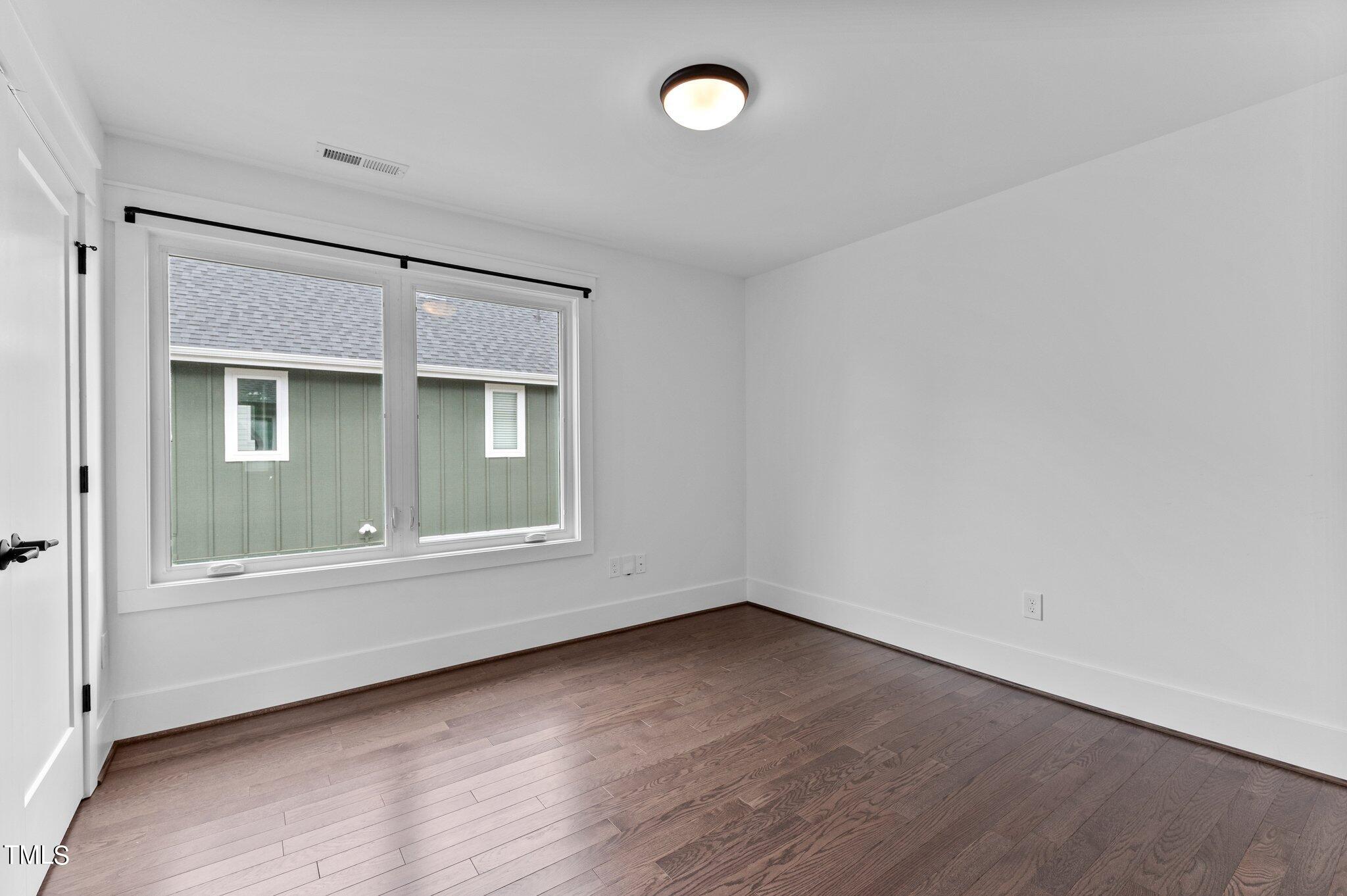 5 Bart Street Raleigh, NC 27610 - Photo 32 of 41 an empty room with wooden floor and windows