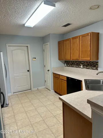 an empty room with wooden floor chandelier fan and windows