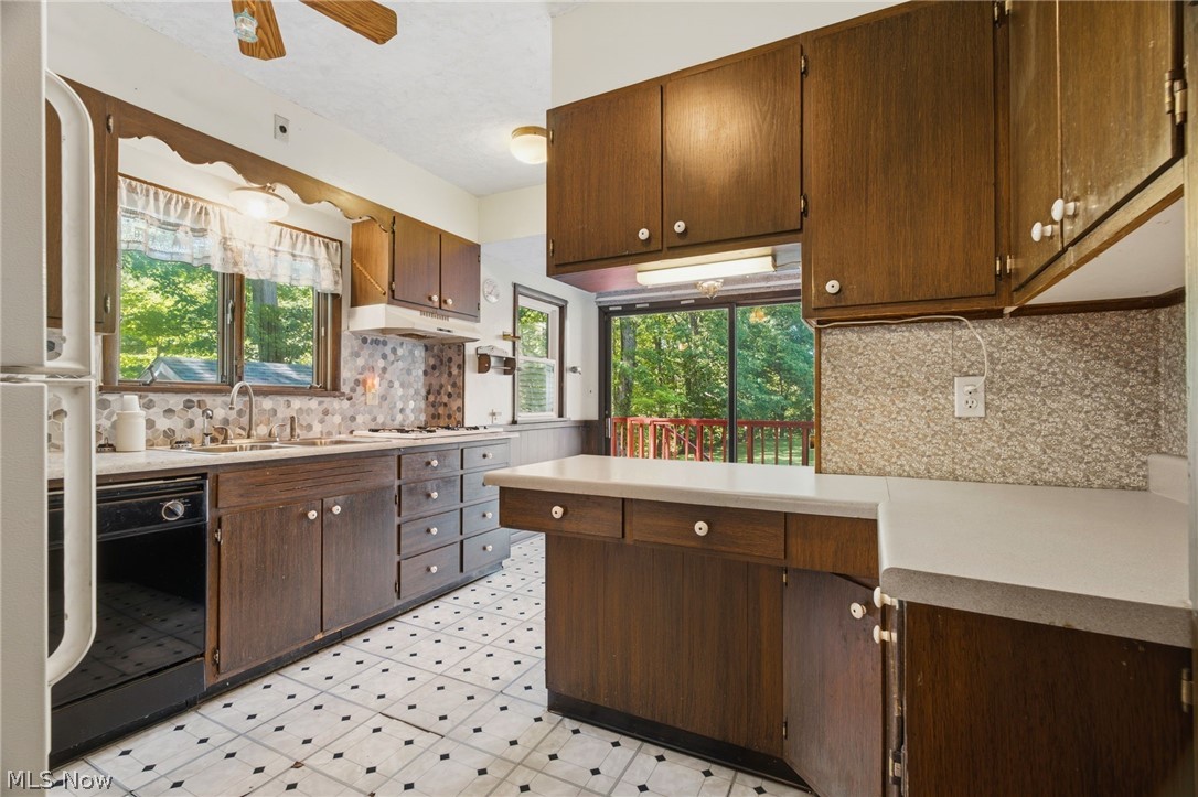759 Runkle Avenue Ashtabula, OH 44004 - Photo 9 of 40 Kitchen featuring wood-finish cabinetry, patterned tile backsplash, and a black-and-white checkered floor