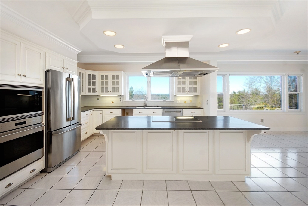 21 Kettle Hole Road Bolton, MA 01740 - Photo 13 of 39 a kitchen with stainless steel appliances granite countertop a stove a sink and a refrigerator