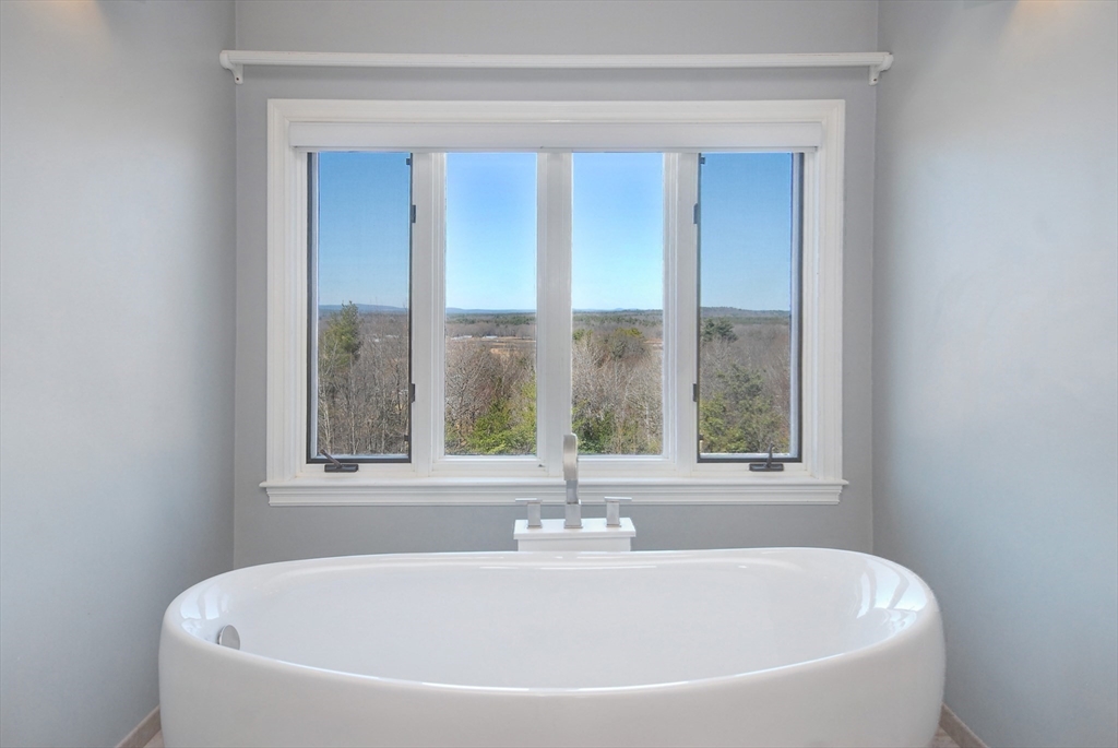21 Kettle Hole Road Bolton, MA 01740 - Photo 8 of 39 a white bath tub sitting in a bathroom next to a window