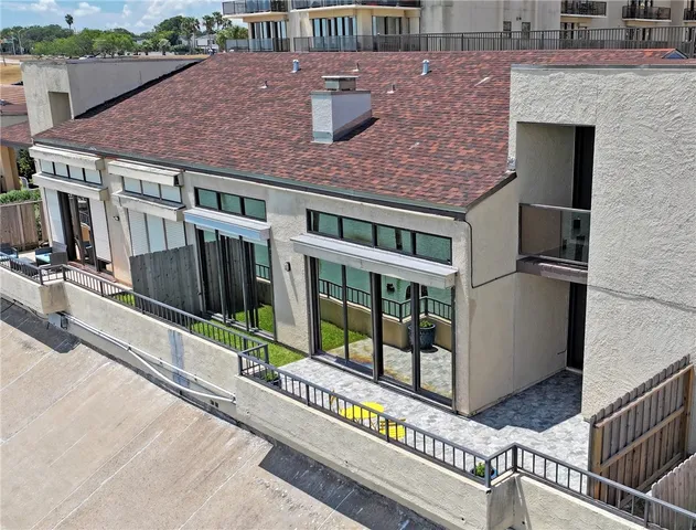 an aerial view of a house with large windows and a small yard