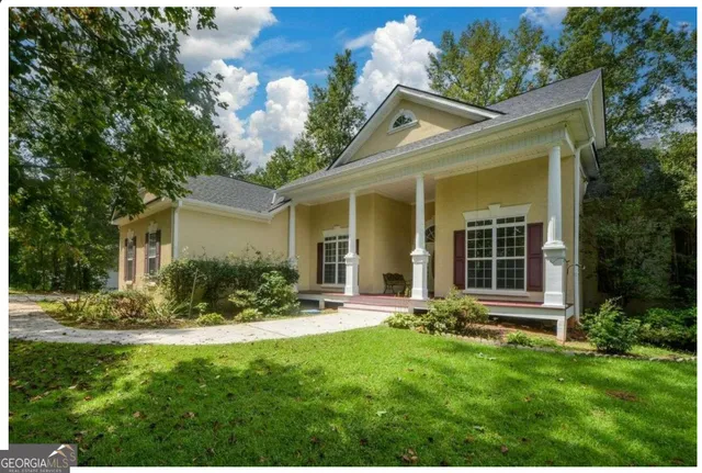 a view of a house with a yard and sitting area
