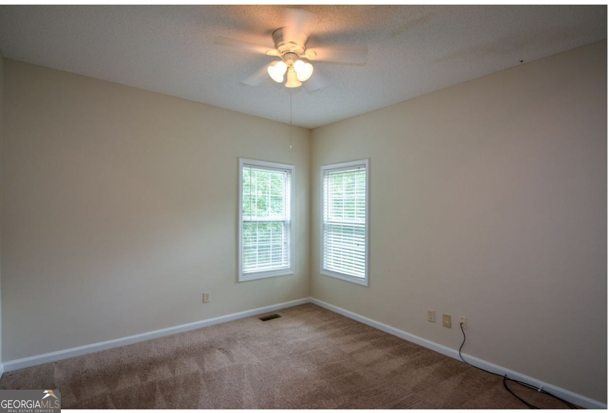 102 Buell Jones Road Carrollton, GA 30117 - Photo 20 of 27 an empty room with windows and ceiling fan