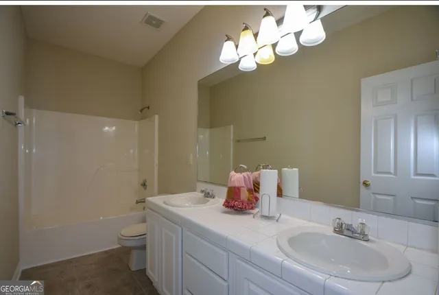 a bathroom with a sink vanity granite and toilet