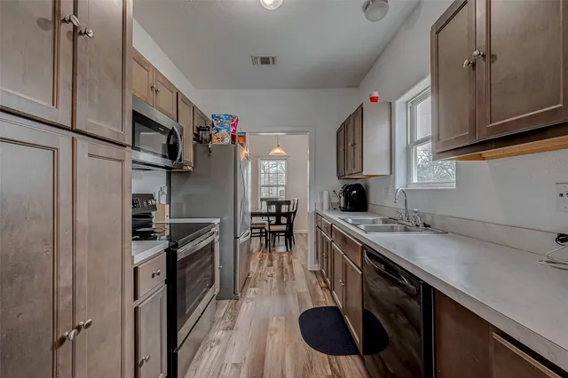 a kitchen with stainless steel appliances granite countertop a sink stove and refrigerator