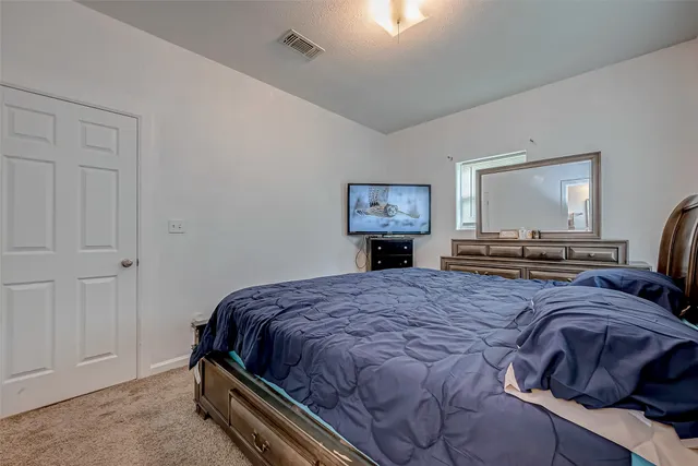 a bedroom with a bed and a painting on the wall