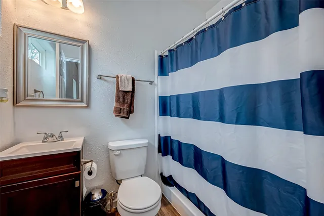a bathroom with a toilet a sink and a mirror