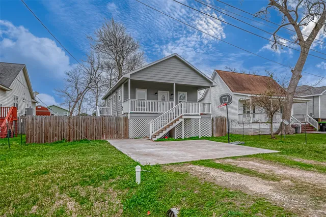 a view of a house with a yard and wooden fence