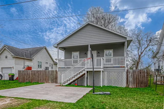 a view of a house with a small yard and wooden fence