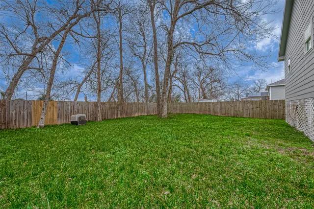 a view of backyard with wooden fence