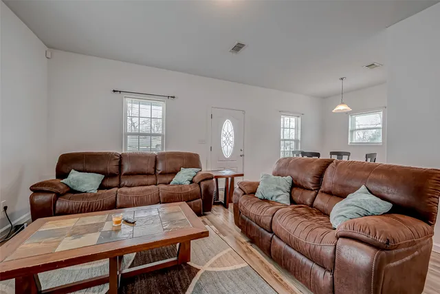 a living room with furniture a view of bedroom and a window