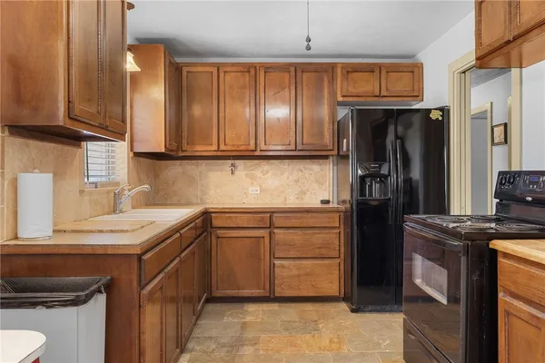 a kitchen with stainless steel appliances granite countertop a refrigerator stove and sink