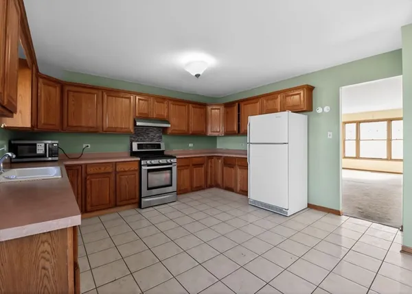 a kitchen with a refrigerator sink and cabinets