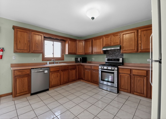 3902 Edgewater Drive Hazel Crest, IL 60429 - Photo 14 of 23 a kitchen with stainless steel appliances granite countertop a stove top oven a sink dishwasher and a refrigerator