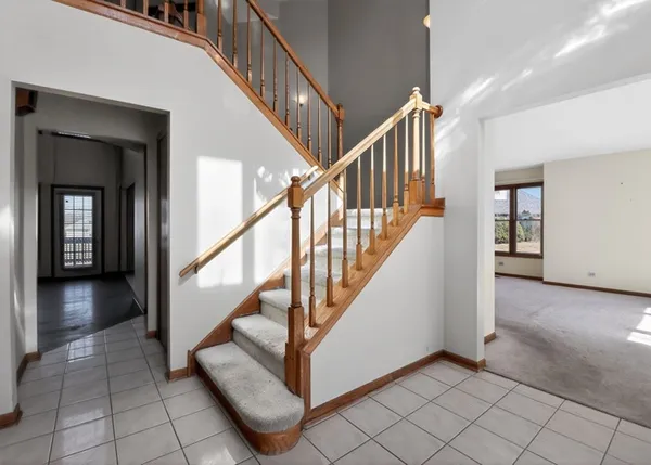 a view of staircase with lots of frames and a rug