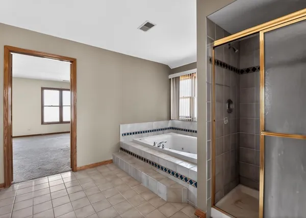 a bathroom with a tub a sink and a mirror