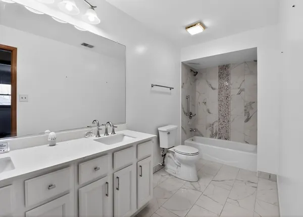 a bathroom with a double vanity sink toilet and shower