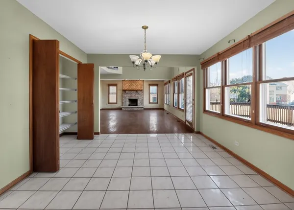 wooden floor in an empty room with a fireplace and a window