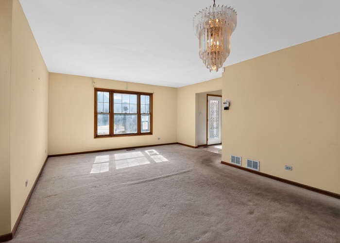 3902 Edgewater Drive Hazel Crest, IL 60429 - Photo 10 of 23 an empty room with a chandelier fan and windows